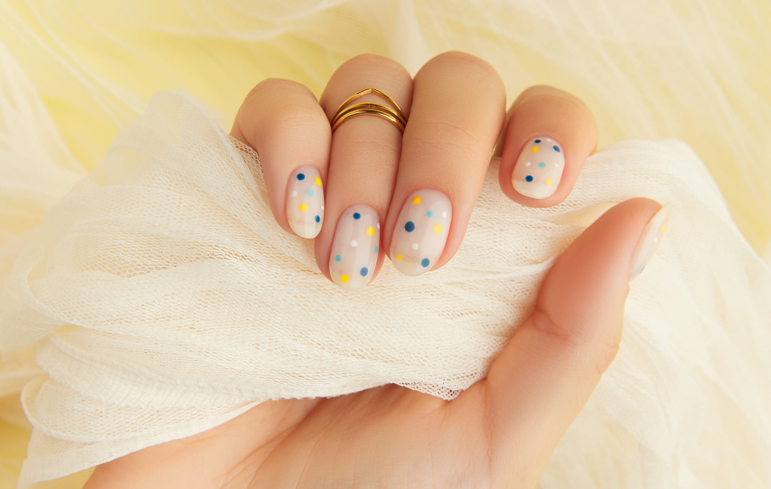 womans-hand-with-trendy-polka-dot-summer-manicure-min